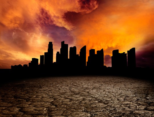 City overlooking desolate desert landscape with cracked earth