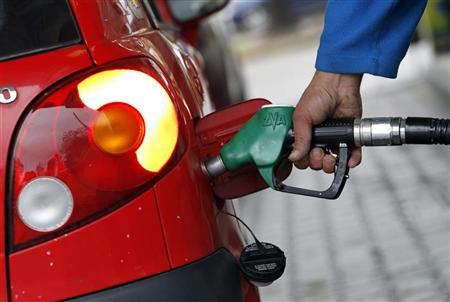 A driver refuels his car at a gas station in Milan