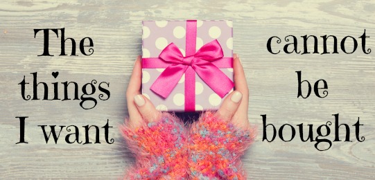 Female hands holding gift on wooden table.