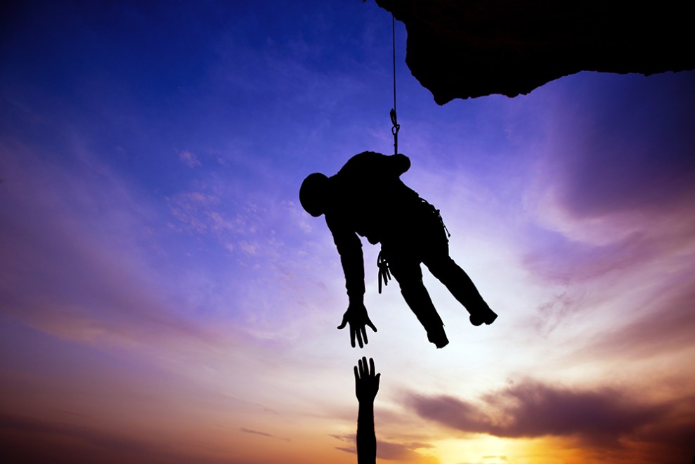 Silhouette of helping hand between two climber